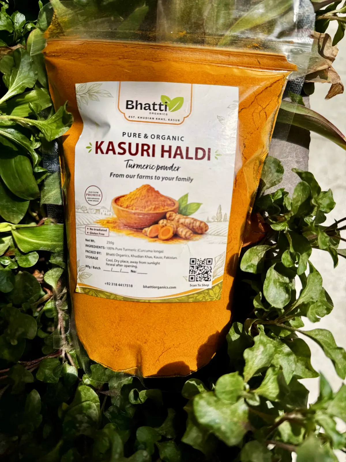 A pouch of Bhatti Organics Kasuri Haldi among fresh green leaves